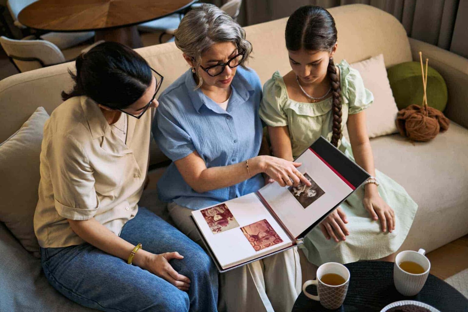 Woman sitting on couch with two children reading a book